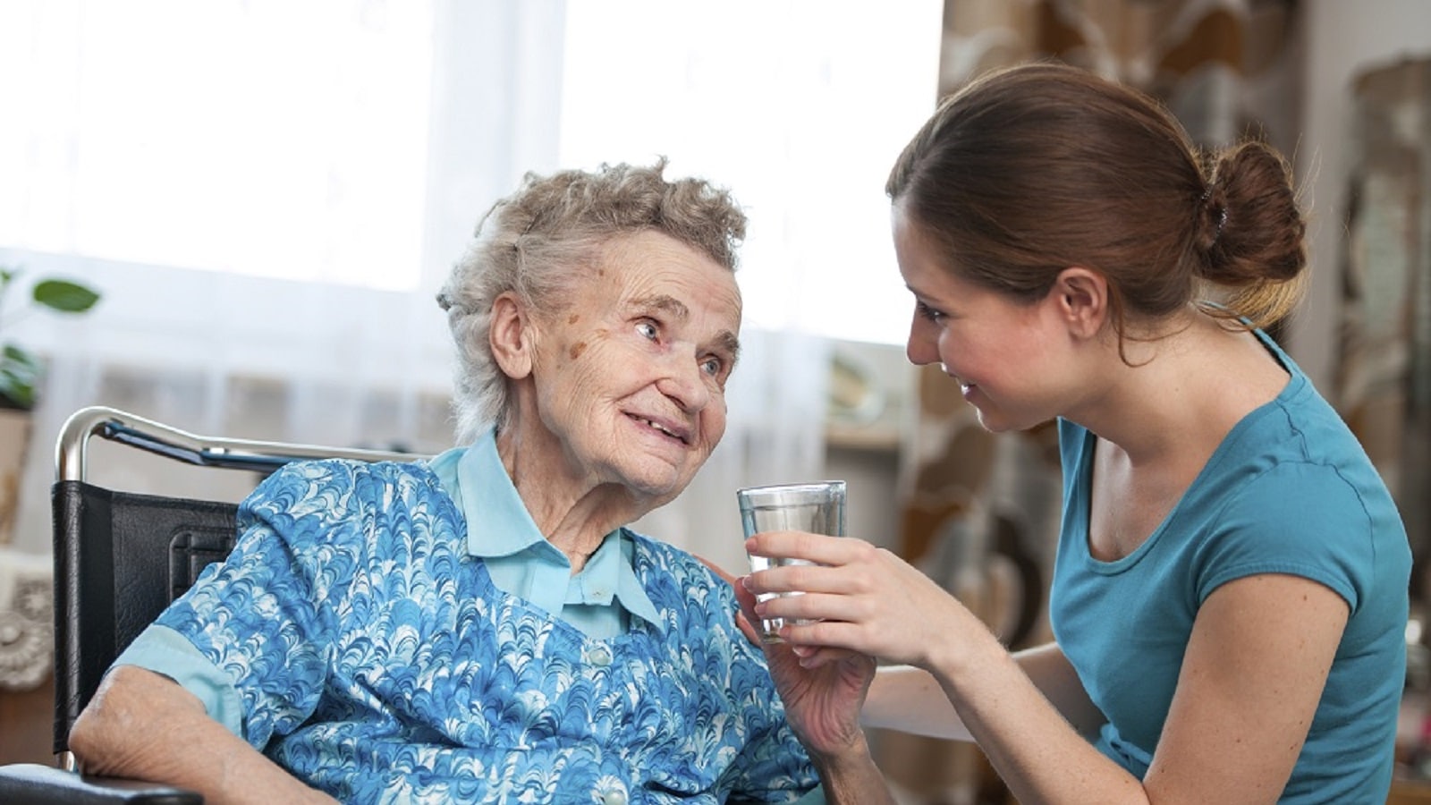 Photo: Healthcare worker assisting patient with drinking glass