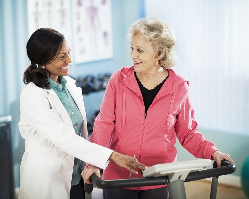 Photo: Senior woman exercising on treadmill with healthcare worker