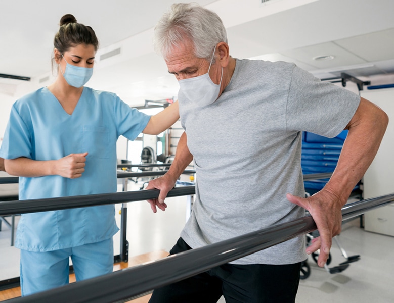 Photo: Healthcare worker assisting patient with walking