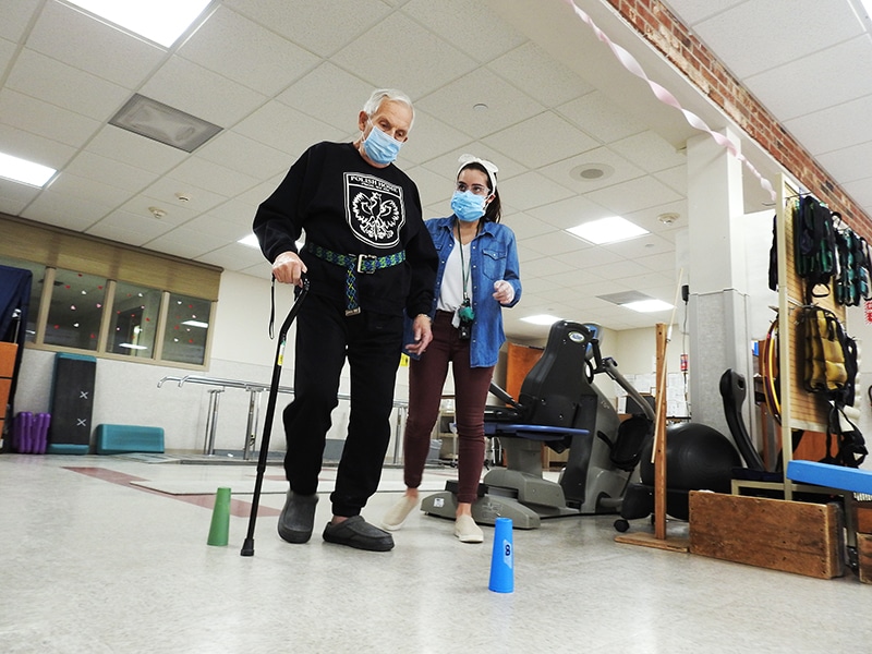 Photo: St. Camillus employee assisting patient with walking