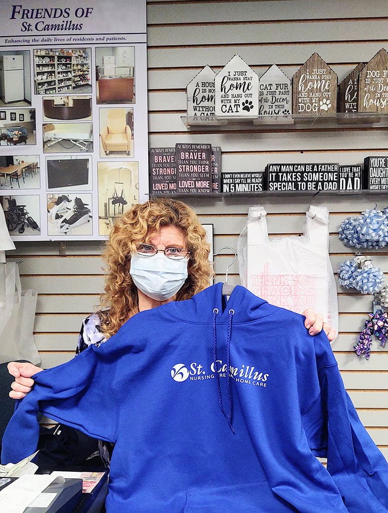 Photo: St. Camillus gift shop employee holding sweatshirt